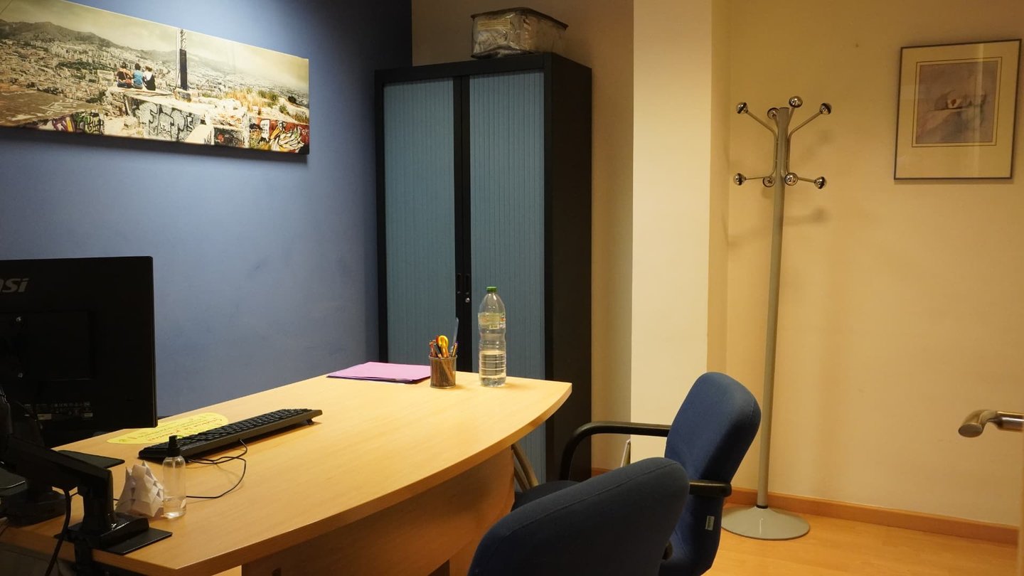 Despacho de consulta con mesa de trabajo y perchero