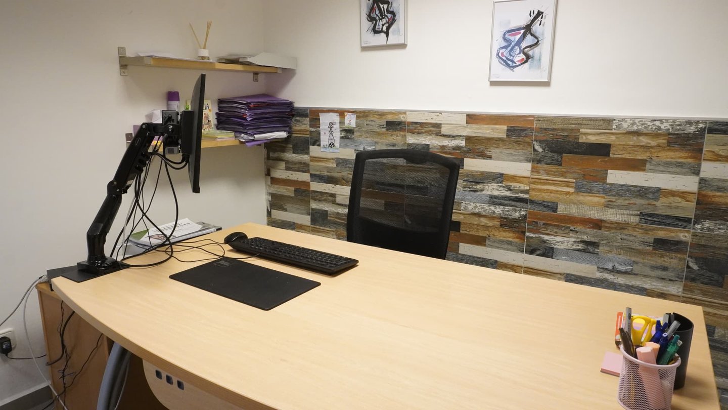 Despacho de evaluación con mesa despejada y archivadores en la estantería
