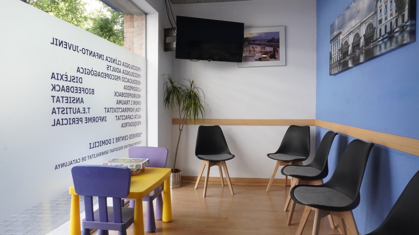 Mesa infantil con sillas de colores junto a las sillas de adultos en la sala de espera